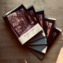 A number of copies of new book "Our Time Is A Garden" fanned out on a table