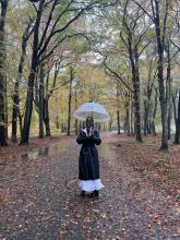 Samantha Likonde at the Burn Staff member Samantha Likonde stands in a forest holding an umbrella