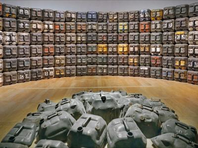 Installation de Romuald Hazoumè 2015 Installation présentée dans l'exposition "Expression(s) décoloniale(s) #2", Château des ducs de Bretagne, Nantes Image of oilcans stacked into a wall. Image by Jean-Pierre Dalbéra. https://www.flickr.com/photos/dalbera/51422594515/