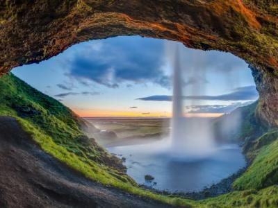 Sunset view from the back of the Seljalandsfoss waterfall, Suðurland, Iceland.