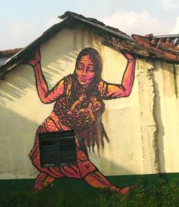 Street art from Colombia of a smiling woman holding up a roof, with babies held in a sling.